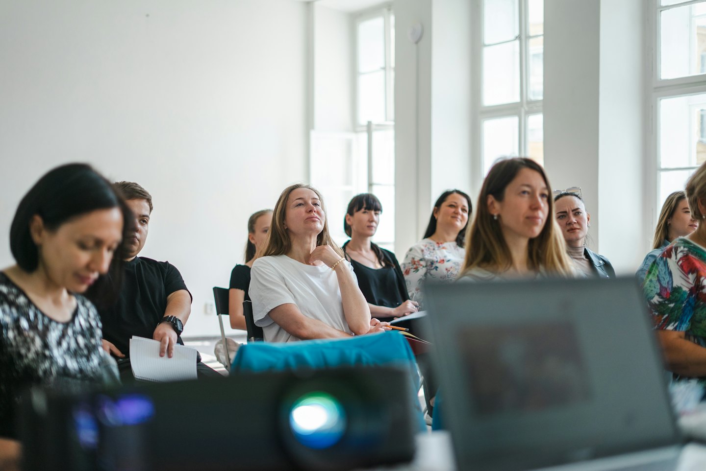 Publik kuulab tähelepanelikult heledas konverentsiruumis.